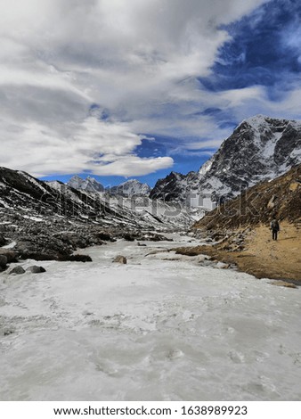 Frozen river and lone trekker. Photo from a trek to Everest Base Camp in Nepal during March 2019.