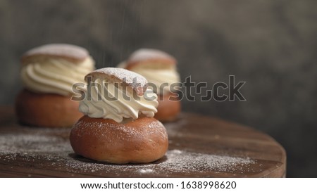 Traditional winter sweet: Semla or semlor, flavored with cardamom, filled with almond paste & whipped cream from Sweden, Finland, Estonia, Norway & Denmark for Shrove Monday, fat Tuesday & Easter Royalty-Free Stock Photo #1638998620