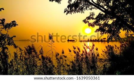sunset and view of the lake looks awesome and the warmer tone off the nature make the picture Amazing.