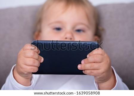 Little Girl With Mobile Phone At Home
