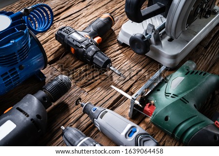 Various Power Tools Laying On Wooden Desk Royalty-Free Stock Photo #1639064458