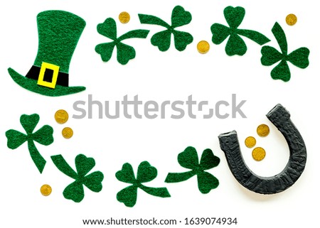 Composition for St. Patrick's Day.
Decorating paper with green clover or shamrocks, leprechaun hat and horseshoe.
White background top view,flat lay, mockup
