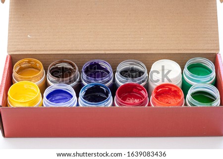 Tempera paints buckets on the table in a workshop, selective focus, close up, on white background. Set of gouache - bouquet
