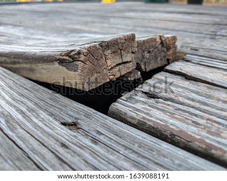 Wooden deck floor boards coming up that are old, warped and weathered, needing to be nailed and repaired Royalty-Free Stock Photo #1639088191
