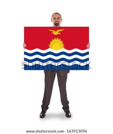 Smiling businessman holding a big card, flag of Kiribati