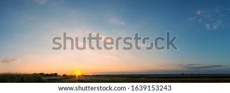 
panoramic sunset view over fields in summer Royalty-Free Stock Photo #1639153243