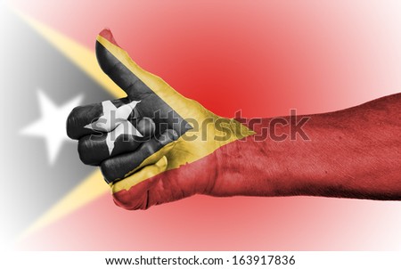 Old woman giving the thumbs up sign, isolated, flag of East Timor