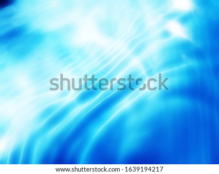 The​ metal​ texture​ of surface​ blue​ water​ reflected​ by​ sunlight​ for​ blue​ background​