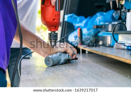 close up technician catch and drilling key or switch engine start of sedan car by electric drill for repair on table
