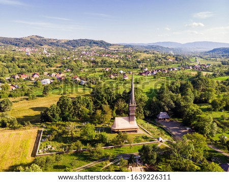 Beautiful aerial view on the Church of the Archangels Michael and Gabriel in Surdesti, Maramures County near Baia Mare, Romania. Traditional Maramures wooden architecture. UNESCO world heritage site. Royalty-Free Stock Photo #1639226311