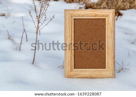 Empty Wooden Picture Frame Laying on Snow 