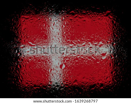 Denmark flag under glass with drops of water. Abstract photo on a black background