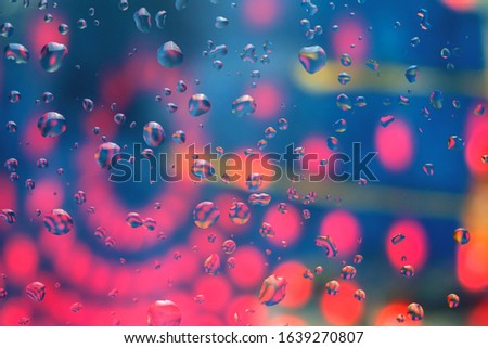 Water drops on a colorful abstract background with gradient blue, red and orange colors