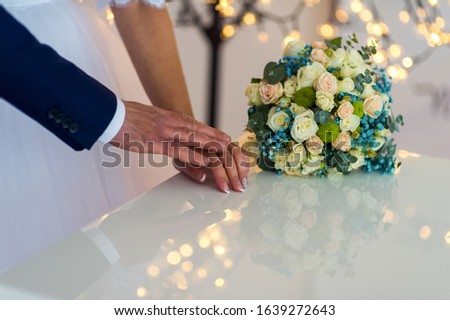 picture of man and woman holding hands over wedding flowers background. Marriage concept.