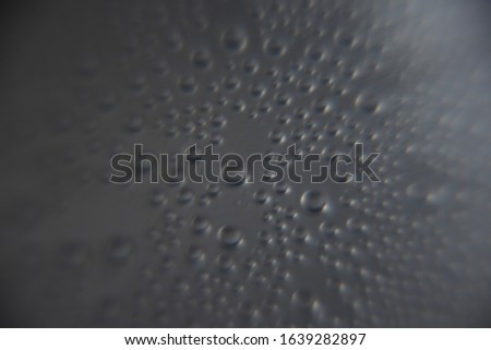 Abstract background close up water drops on dark and bright background in cold bottle.Wallpaper texture background.
