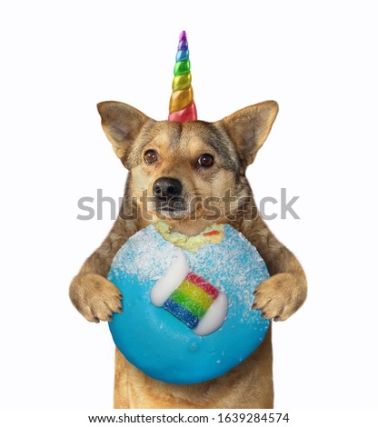 The beige dog unicorn is holding a blue bitten donut. White background. Isolated.