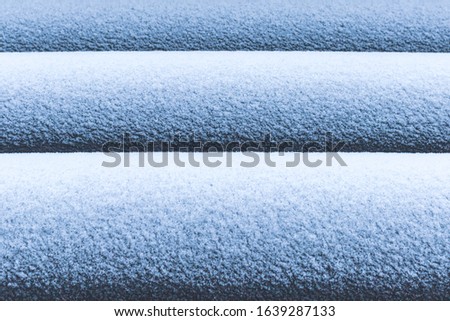 The background is formed by snow that lies on the pipes forming a gradient.
