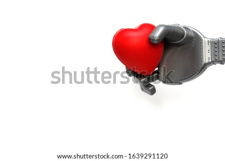 Robot hand holds a red heart. The concept of man and robot. Robotic Valentine, who will give you a red bright heart. White background. Place for text.