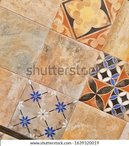 Brown ceramic tile with floral pattern for wall and floor decor. Concrete stone surface background. Texture for interior design project.