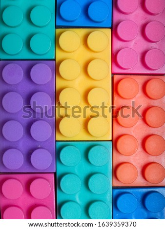 Multiple colored plastic building blocks on a gray textured background