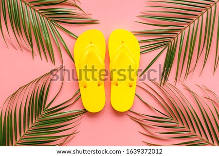 Summer vacation on the beach.Yellow   Flip-flops and palm leaves. Pink  background top view mockup