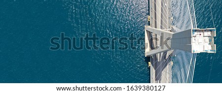 Aerial drone ultra wide photo of suspension cable bridge over deep blue sea