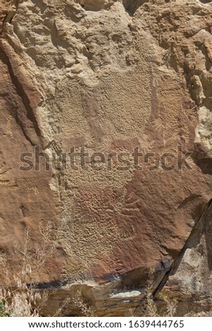 Strange shapes and figures that have been carved into the ancient sandstone rocks at Legend Rock State Petroglyph Site, Wyoming.