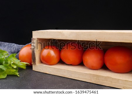 fresh tomatoes on the a wooden box