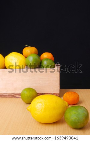 Still life with oranges, lemons on black background