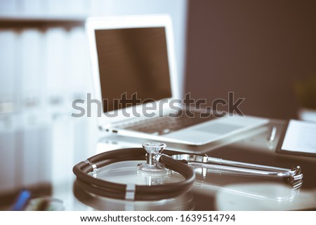 Stethoscope, prescription medical form lying on glass table with laptop computer. Medicine or pharmacy concept. Medical tools at doctor working table