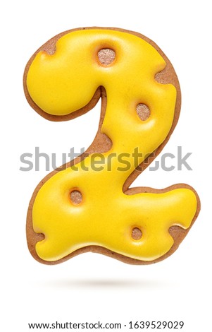 Number 2 yellow homemade gingerbread biscuit isolated at white background.