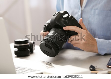 Journalist with camera working at table, closeup