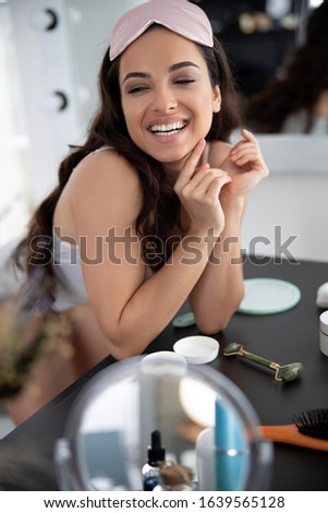 Charming girl with sleep mask on head looking away and laughing stock photo