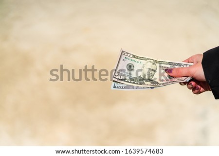 Woman hand holding and giving money. World money concept, close up of USD banknote, photo of American Dollars currency. Hand holding money, American dollars