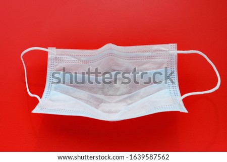 inside of an used medical face mask on red background
