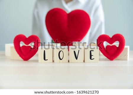 Red heart shapes and wooden blocks with text LOVE on desk, Concept for valentines day and romantic moment.