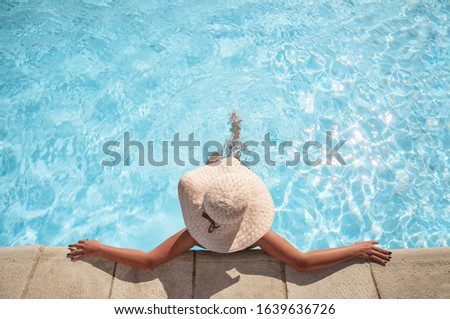 Young woman relaxing in the swimming pool with copy space