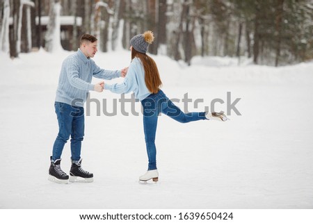 Couple girl and a guy learn to skate in the winter.