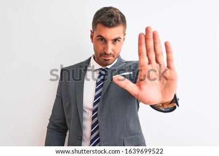 Young handsome business man wearing suit and tie over isolated background doing stop sing with palm of the hand. Warning expression with negative and serious gesture on the face. Royalty-Free Stock Photo #1639699522