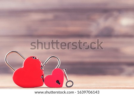 Valentine heart shaped padlocks and key on brown background