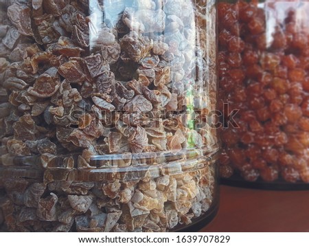 Dried Chinese brown plum and umber color in big clear glass jar