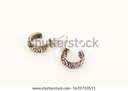 Women's ear jewelry. Two small earrings lie on a white background of a horizontal close-up photo