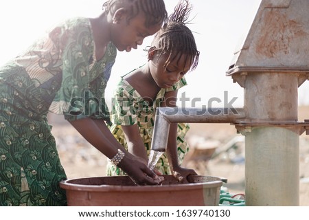 Young Native African Infant Saving Crisp Water for a lack of water symbol Royalty-Free Stock Photo #1639740130