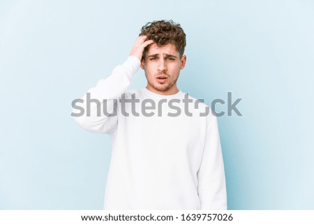 Young blond curly hair caucasian man isolated tired and very sleepy keeping hand on head.