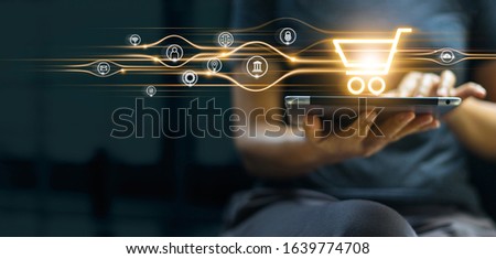 Online shopping and payment, Man using tablet with shopping cart icon, Digital marketing, Banking and finance on dark blue background.