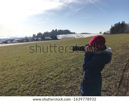 Cute Girl child taking pictures in a Beautiful landscape