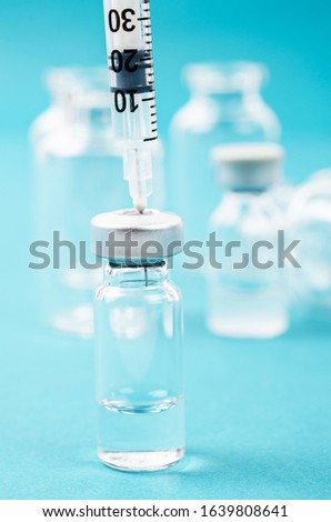 Vaccine vial dose with needle syringe, medical concept vaccination in laboratory background.
