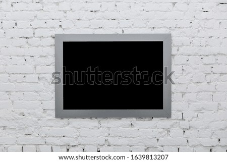 Empty frame from a painting on a white brick wall. Black place mock up