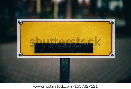 Yellow plate for your text with dots for reading by hands for the blind. Signpost sign for the blind and disabled. Signpost sign in the park for your text. out of focus Copy Space