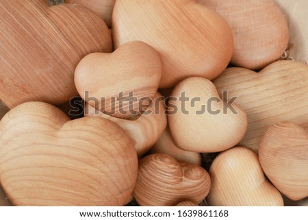 Background of big and small heart-shaped things made of wood. Horizontal.